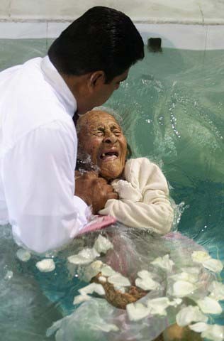 غسل تعمید یک زن کهنسال در آیینی سالانه در کلیسایی در مکزیک