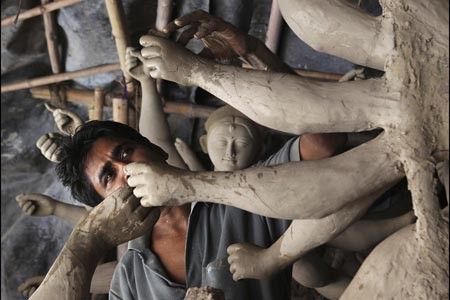 هنرمندي در ميان بت ها در یک کارگاه آموزشی پیش از جشنواره دورگا در دهلی نو 